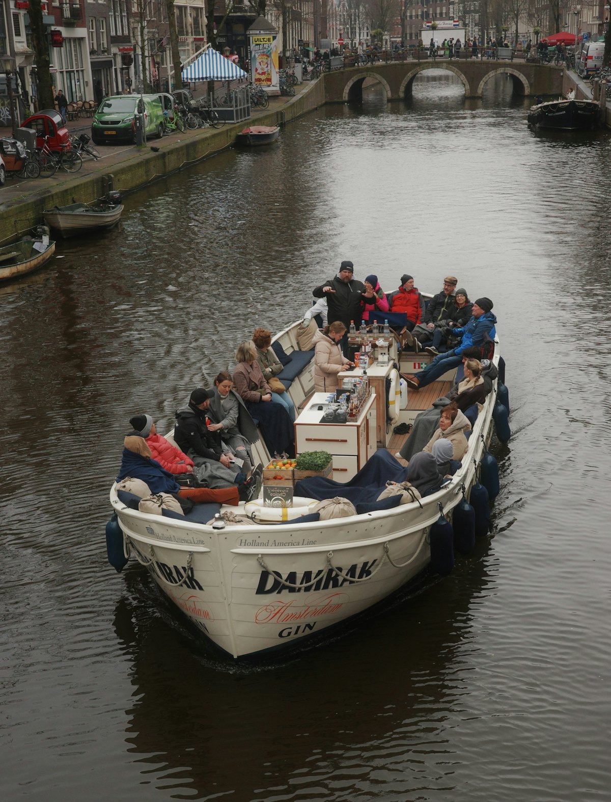 Een volle boot met passagiers op de gracht