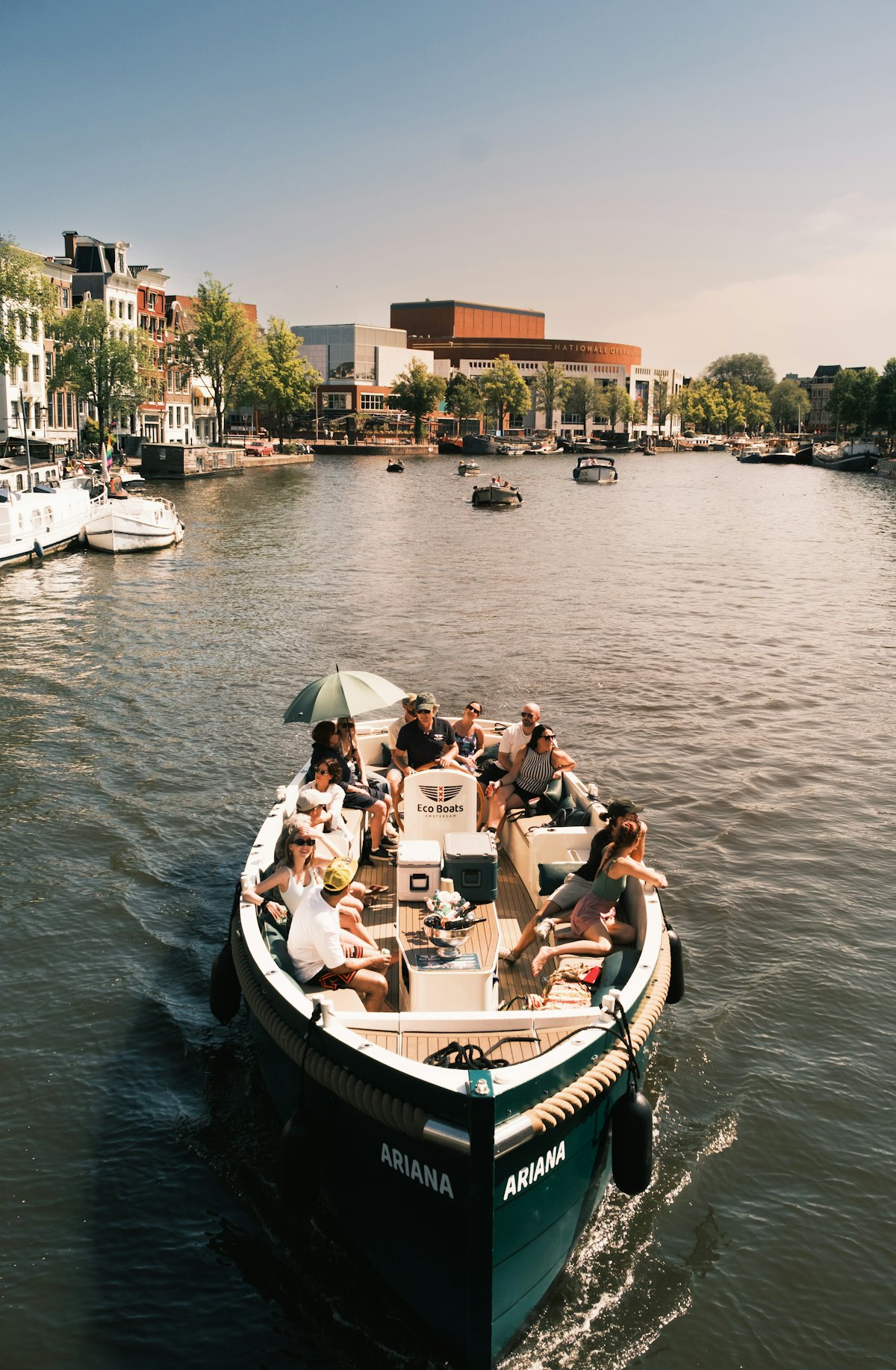 Een groep in een open boot op een Amsterdamse gracht
