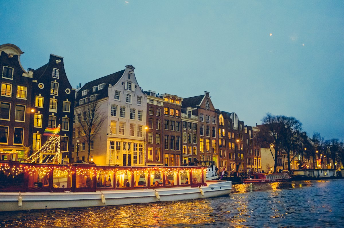 Een verlichte boot op de gracht bij schemering
